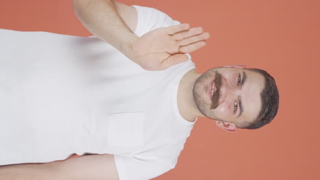 Vertical-video-of-Happy-man-waving-at-camera.